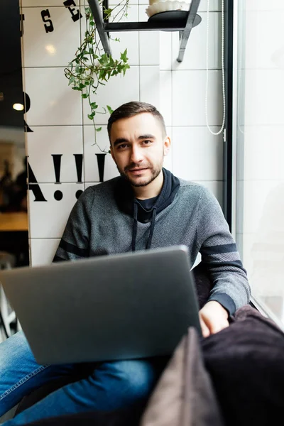 Hombre guapo con portátil en la cafetería navegar en Internet o chating en la aplicación — Foto de Stock