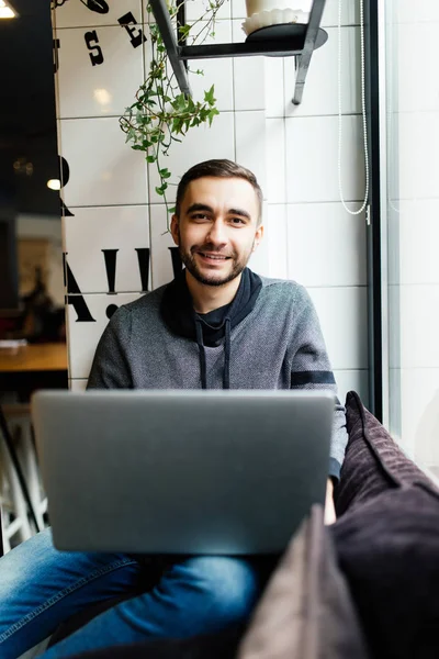 Kafede dizüstü bilgisayar ile yakışıklı adam Gözat Internet veya kitap App — Stok fotoğraf