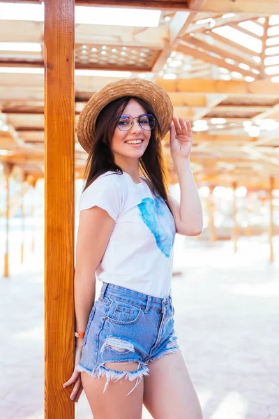 Gyönyörű nő divatos napszemüveg és a nap kalap nyaralni közelében uszoda resort nyugágyon napozás — Stock Fotó