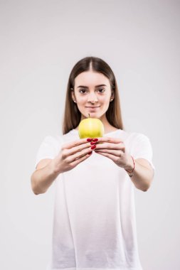 Beyaz bir arka planda elma tutan mutlu ince kadın. Kameraya bakıyorum.