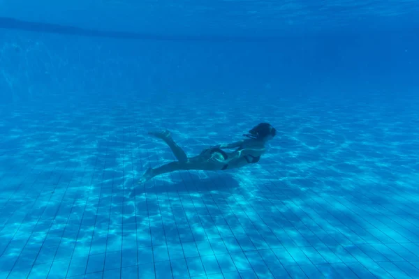 Retrato de mujer joven con bikini bajo el agua en la piscina. Vacaciones, diversión, concepto de estilo de vida . — Foto de Stock