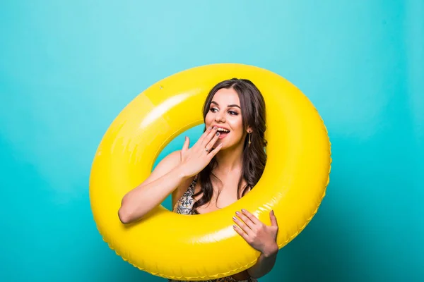 Jeune femme de beauté en maillot de bain et chapeau de paille avec anneau gonflable jaune choqué isolé sur fond vert — Photo