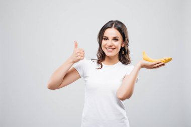 portre portre çekici beyaz gülümseyen kadın esmer muz ile izole üzerinde beyaz arka plan Yaşasın gösterir. Sağlıklı gıda kavramı. Cilt Bakımı ve güzellik. Vitaminler ve mineraller.