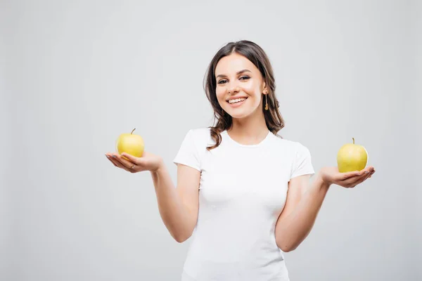 Jovem feliz sorrindo equilíbrio mulher com duas maçãs, isolado em branco — Fotografia de Stock