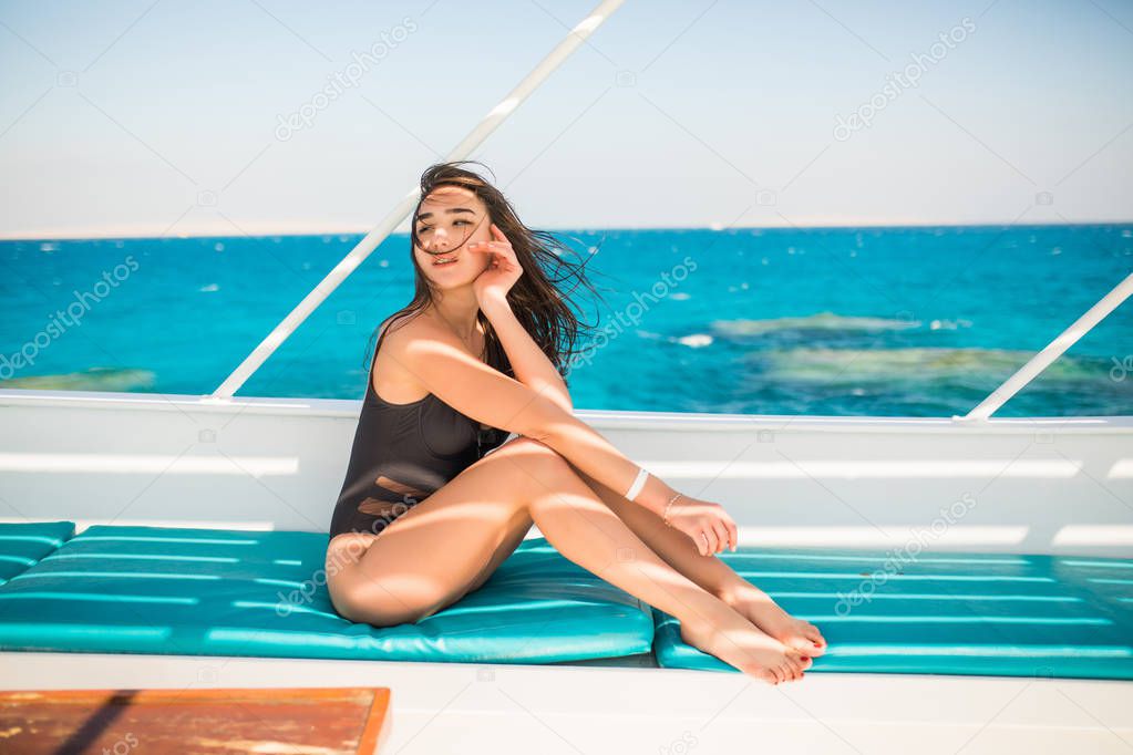 Young Woman relaxing on board of sailing yacht in opean sea