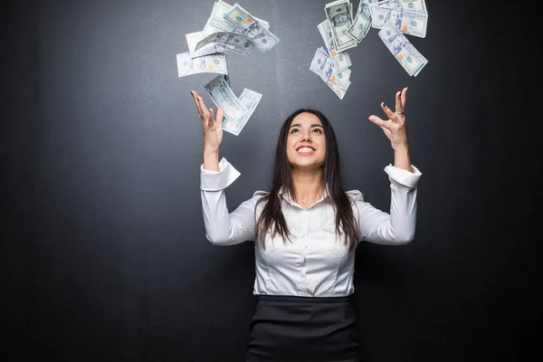 Mujer de negocios feliz bajo una lluvia de dinero hecha de dólares aislados en negro — Foto de Stock