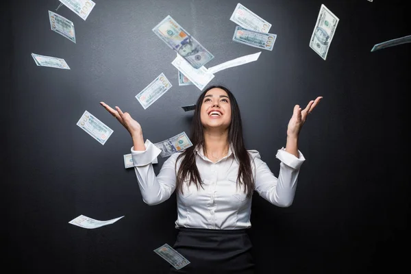 Mujer de negocios feliz bajo una lluvia de dinero hecha de dólares aislados en negro — Foto de Stock