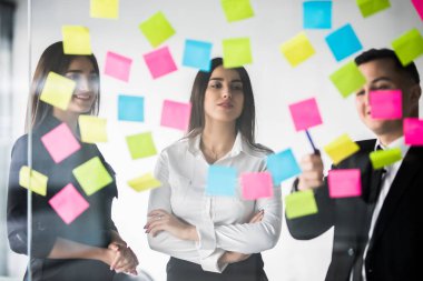 Güzel iş adamları çıkartmaları ve marker, fikirleri tartışmak ve Office toplantısında gülümseyen kullanıyorsunuz. Takım çalışması.