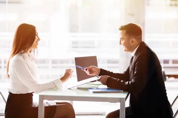 Affärsman och affärskvinna underteckna ett kontrakt. Nöjd med lån villkor kvinna sjunger kontrakt samtidigt sitter vid skrivbord framför manliga banktjänsteman på kontor. — Stockfoto