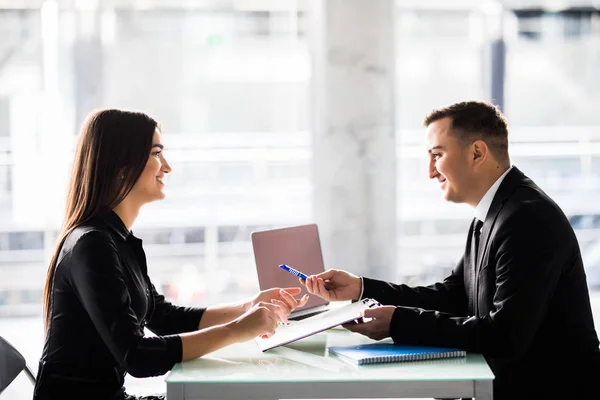 Empresarios sentados en una mesa y firmando un contrato en la oficina — Foto de Stock