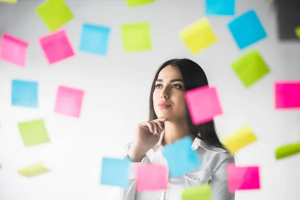 Zakelijke vrouw lijm stickers en denken over het project. Vrouw schaven denken over stickers. — Stockfoto