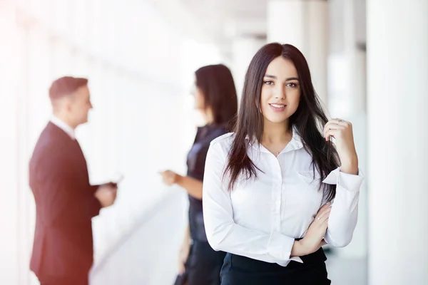Mujer de negocios liderando un equipo corporativo frente a colegas que hablan —  Fotos de Stock