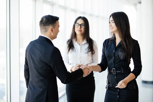 Empresario y empresaria estrechando las manos en el salón de la oficina en la reunión informal — Foto de Stock