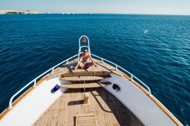 Yakışıklı yaz bir yatta. Yat, yat deste oturur üzerine getirin