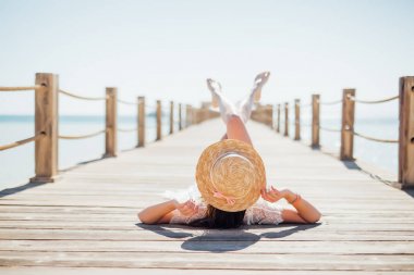 Portre siyah bikini denizde ahşap iskele üzerinde yalan güneşlenme içinde çekici kadın portresi. Yaz meslek