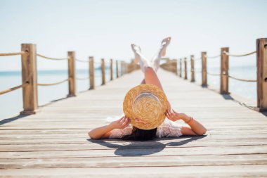 Portre siyah bikini denizde ahşap iskele üzerinde yalan güneşlenme içinde çekici kadın portresi. Yaz meslek