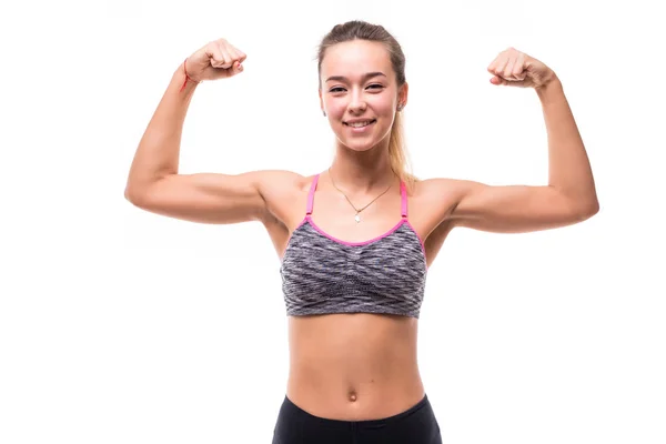 Mulher fitness animado isolado no fundo branco. Modelo feminino caucasiano sorrindo e mostrando músculos — Fotografia de Stock