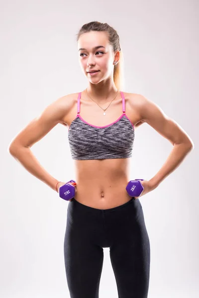 Beyaz arka plan üzerinde izole ağırlık tutan oldukça sportif kadın portresi — Stok fotoğraf