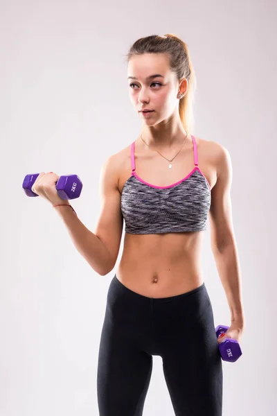 Kadın beyaz arka plan üzerinde izole el ağırlıkları ile spor ekipmanları pratikte — Stok fotoğraf