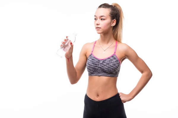 Спортивна м'язова жінка п'є воду на білому тлі — стокове фото