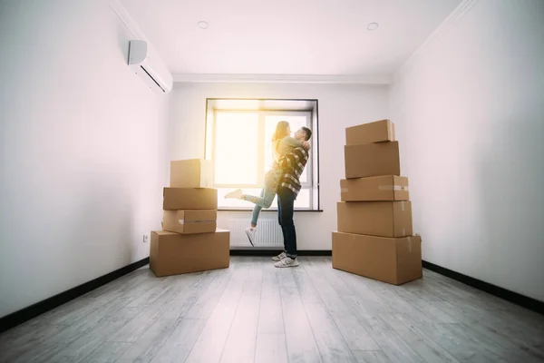 Inteckning, människor och fastigheter koncept - lyckliga paret kramas på tomma rum i nya hem — Stockfoto