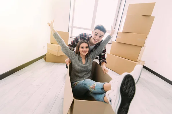 幸せな若いカップル、段ボール箱で楽しんで移動日の新しい家. — ストック写真