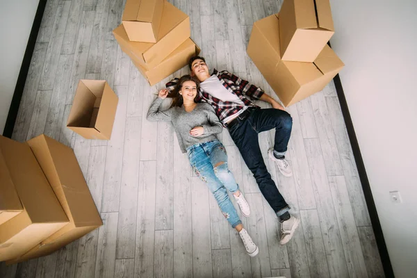 Vista de alto ângulo de um casal fazendo uma pausa de se mudar para seu novo apartamento — Fotografia de Stock