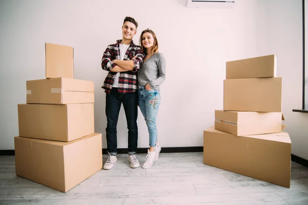 Unga lyckliga par med lådor i lägenheten efter flytten i nya lägenheten — Stockfoto