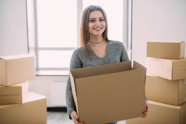 Porträtt av vackra unga brunett packning bära några lådor att flytta in i sitt nya hem — Stockfoto