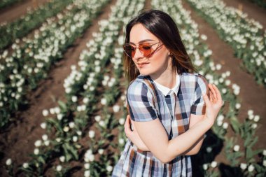 Mutlu kadın güneş gözlüğü alanındaki beyaz laleler