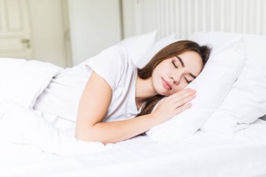 Onun yatağında uyuyan kadın. Yatakta uyuyan güzel genç gülümseyen kadın