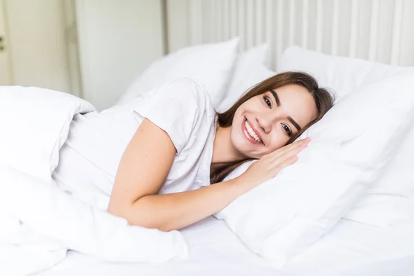 Jeune heureux dormir sur le côté jeune femme souriant doucement au lit — Photo
