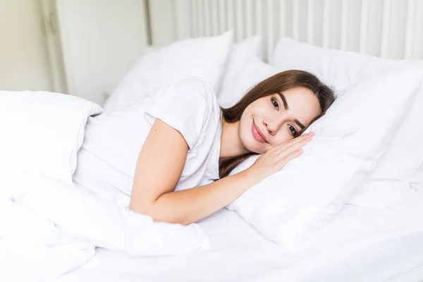 Jeune heureux dormir sur le côté jeune femme souriant doucement au lit — Photo