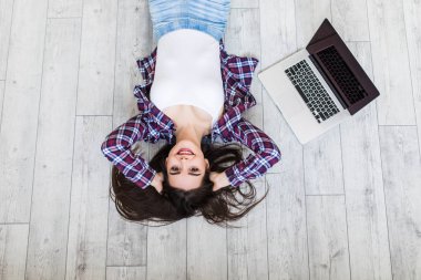 Laptop en iyi manzaralı yerde yatarken gülümseyen güzel kadın