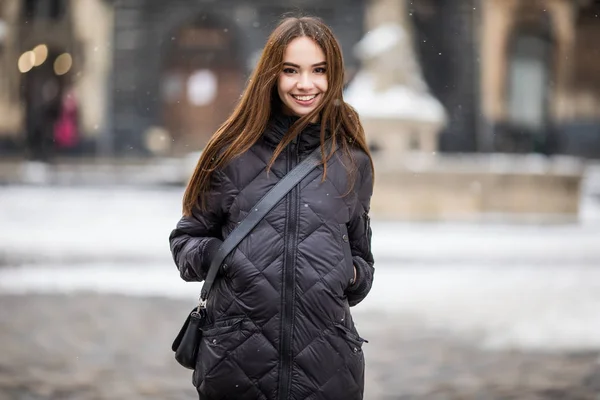 젊은 여자는 따뜻한 미소와 겨울 시간에 거리에 혼자 서 — 스톡 사진