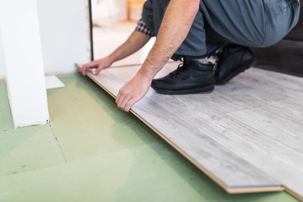 Close up man hands Carpenter worker installing laminate flooring in the new room — Stock Photo, Image
