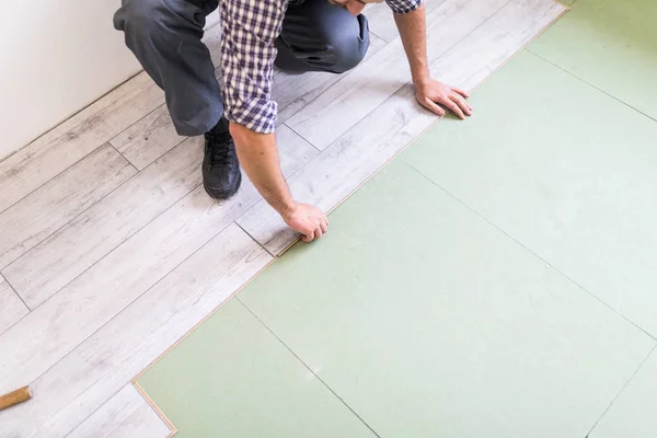 Close up man hands Carpenter worker installing laminate flooring in the new room — Stock Photo, Image