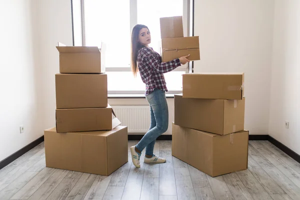 Ung kvinna transporterar en fylld kartong i nya lägenheten — Stockfoto