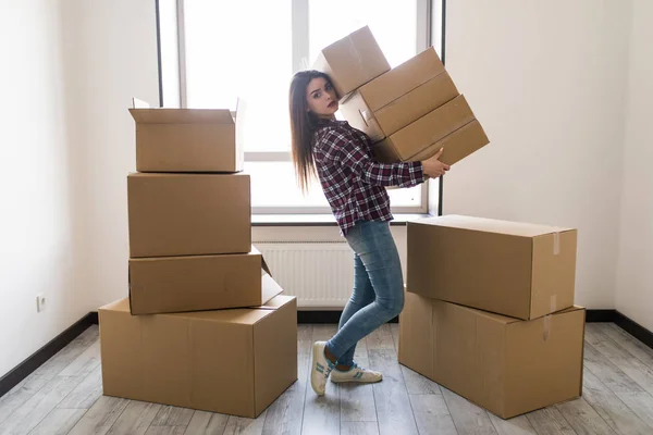 Ung kvinna transporterar en fylld kartong i nya lägenheten — Stockfoto