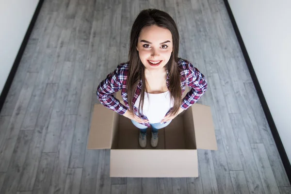 Bir karton kutu ambalaj süre içinde oturan bir bayan. Hareketli kavramı. — Stok fotoğraf