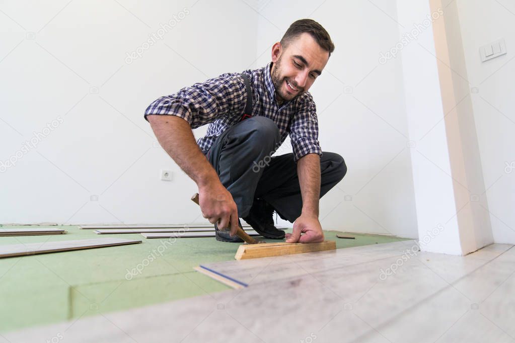 Repair man making the laminate flooring installation