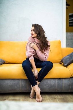 Onun beyaz koltukta evde oturan genç kadın