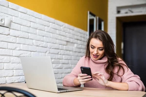 Beautiful girl smile using multiple devices phone and laptop on a table at home — Stock Photo, Image