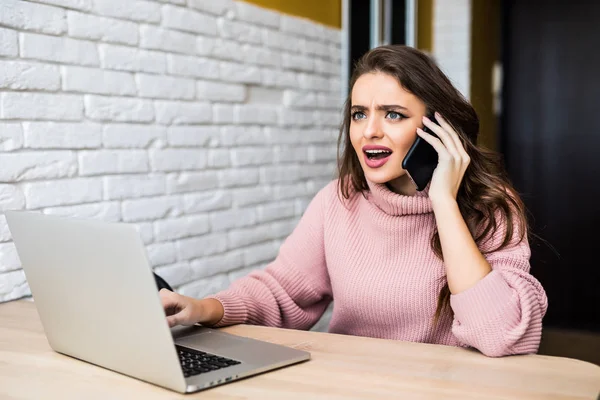 Mulher irritada olhando para um laptop e consultoria no telefone com atendimento ao cliente em seu quarto em um interior da casa — Fotografia de Stock