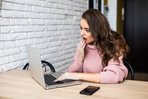 Emotional shocked young woman with laptop at home — Stock Photo, Image