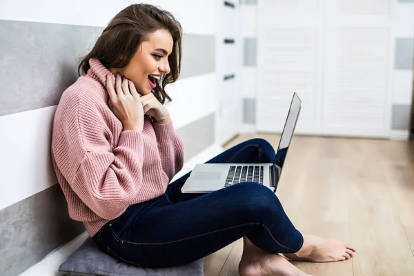 Happy screaming young woman sitting on the floor with laptop computer at home — Stock Photo, Image