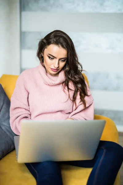 Home, technology, communication and people concept - smiling woman sitting on couch and chatting with laptop computer at home — Stock Photo, Image