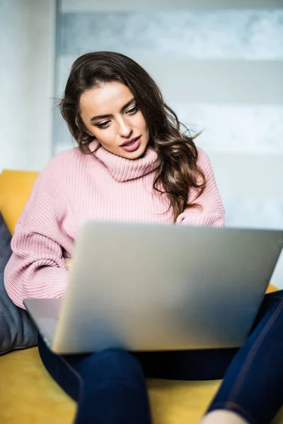 Casual young woman using laptop in living room at home — Stock Photo, Image