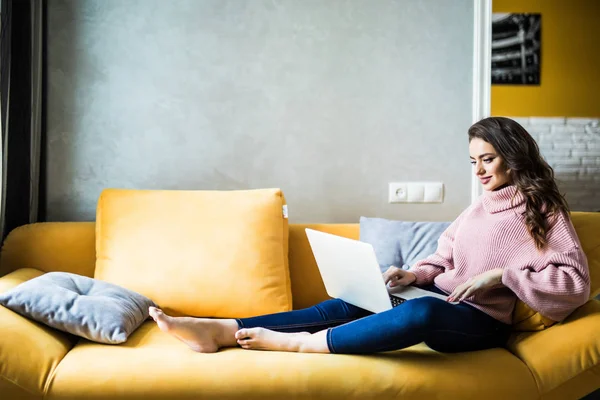 Smiling elegant woman sitting on a sofa with her laptop computer. — Stock Photo, Image