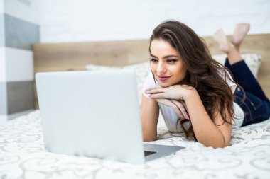 Bacaklarını biraz yatakta yatıyordu onu laptop önünde kaldırdı ile gülümseyen kadın.